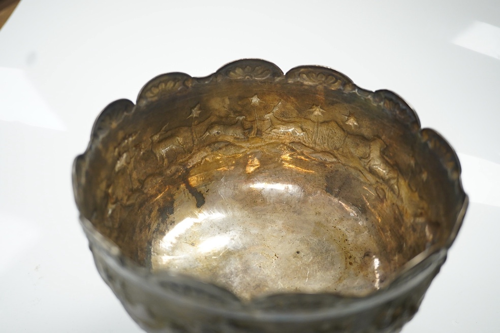 Two early to mid 20th century Indian white metal pedestal bowls, including one embossed with continuous hunting scene, diameters 14.2mm and 13.8mm, 18.1oz. Condition - poor